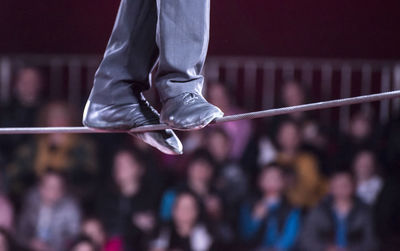 Low section of performer walking on tightrope during event