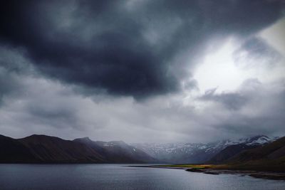 Scenic view of mountains against cloudy sky