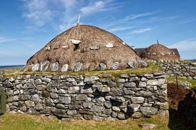 Stone wall of old building against sky