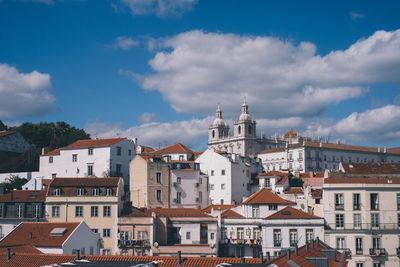 Buildings in city against cloudy sky