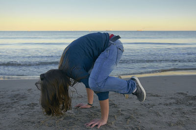 Rear view of person on beach against sky