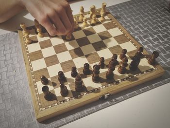 Cropped hand of woman playing chess