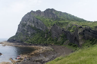 Scenic view of sea and mountains against clear sky