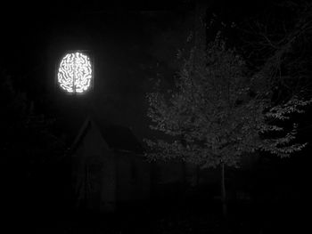 Low angle view of illuminated lamp in building at night