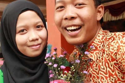 Portrait of happy friends with flower bouquet