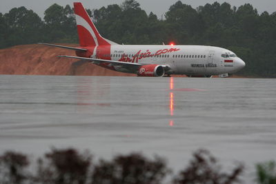 Airplane on airport runway against sky