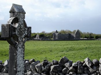 Stone wall on field against sky