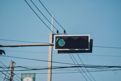 Low angle view of road signal against clear blue sky