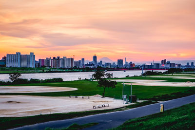 Buildings in city against sky during sunset