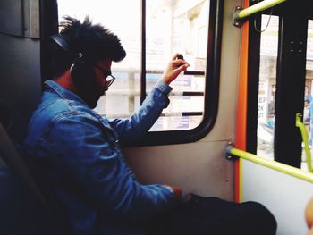 Side view of man sitting in train
