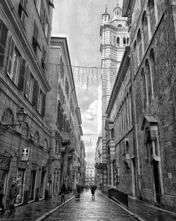 People walking on street amidst buildings in city