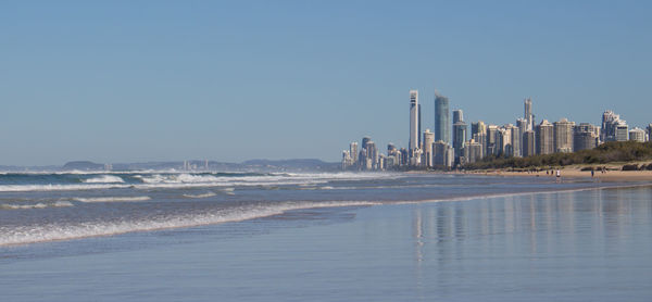 Sea and buildings against clear sky