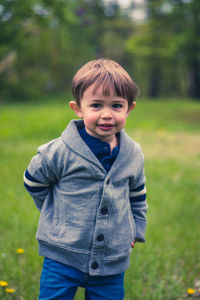 Portrait of smiling boy standing on field
