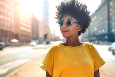 Portrait of smiling young woman standing in city