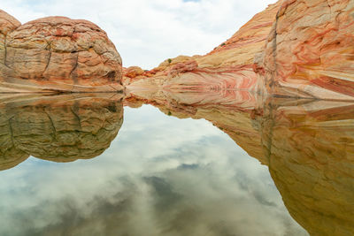 Low angle view of rock formation against cloudy sky