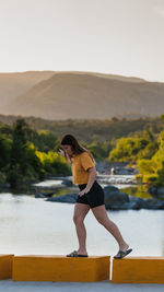 Full length of woman standing on lake against sky