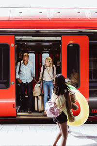 Rear view of people standing on train