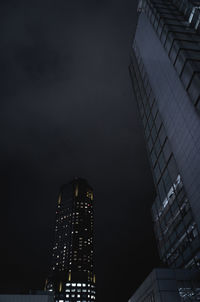 Low angle view of illuminated buildings against sky at night