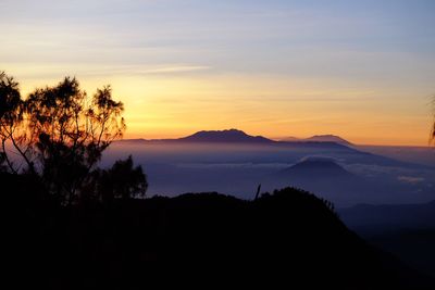 Scenic view of silhouette mountains against sky at sunset