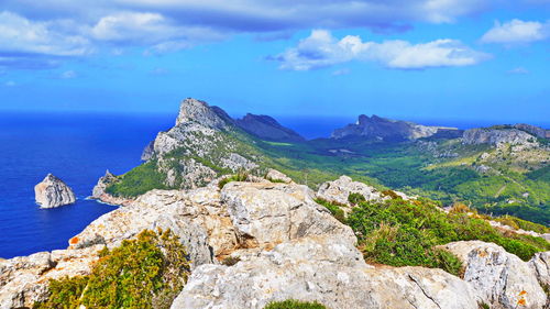 Scenic view of sea and mountains against sky