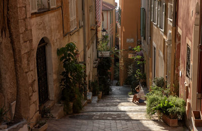 Woman reading in street amidst buildings in city