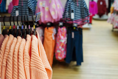 Children clothes hanging on hangers in the shop