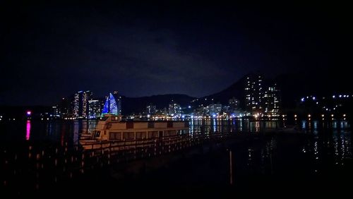 Illuminated cityscape against sky at night