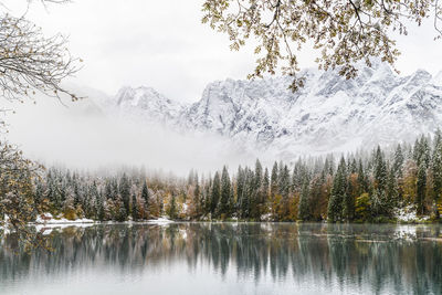 Scenic view of lake by snowcapped mountains during winter