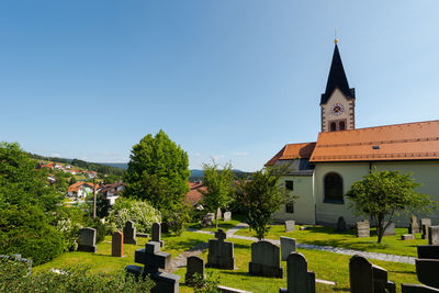 Panoramic view of cemetery and buildings against clear sky
