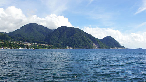 Scenic view of sea and mountains against sky