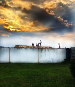 People on field against sky during sunset