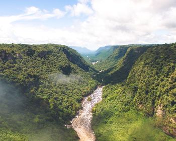 High angle view of river amidst trees against sky