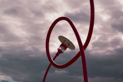 Red danish-design free-form street lamps against evening sky
