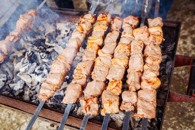 Closeup macro of raw roasted marinated meat barbecue shish kebab shashlik on steel metal skewers 