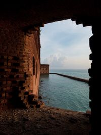 Buildings by sea against sky