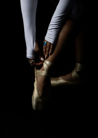 Low section of woman tying shoelace