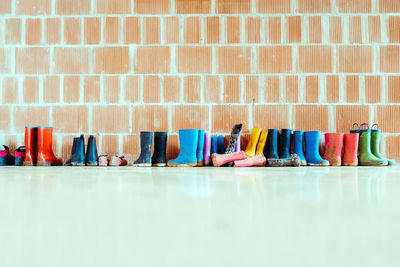 Multi colored chairs against brick wall