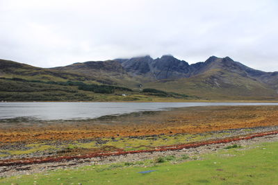 Scenic view of lake by mountains against sky