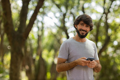 Young man at park on a beautiful sunny day with mobile phone.  working  leisure. green and nature 