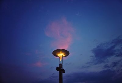 Low angle view of illuminated street light against blue sky