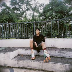 Portrait of young man sitting on staircase