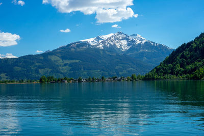 Scenic view of lake and mountains against blue sky