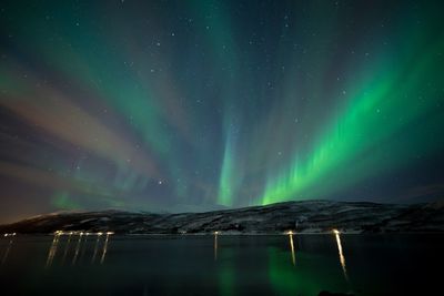 Scenic view of lake against sky at night