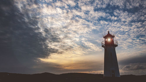 Low angle view of silhouette lighthouse against sky during sunset