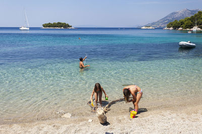 People on beach against sky