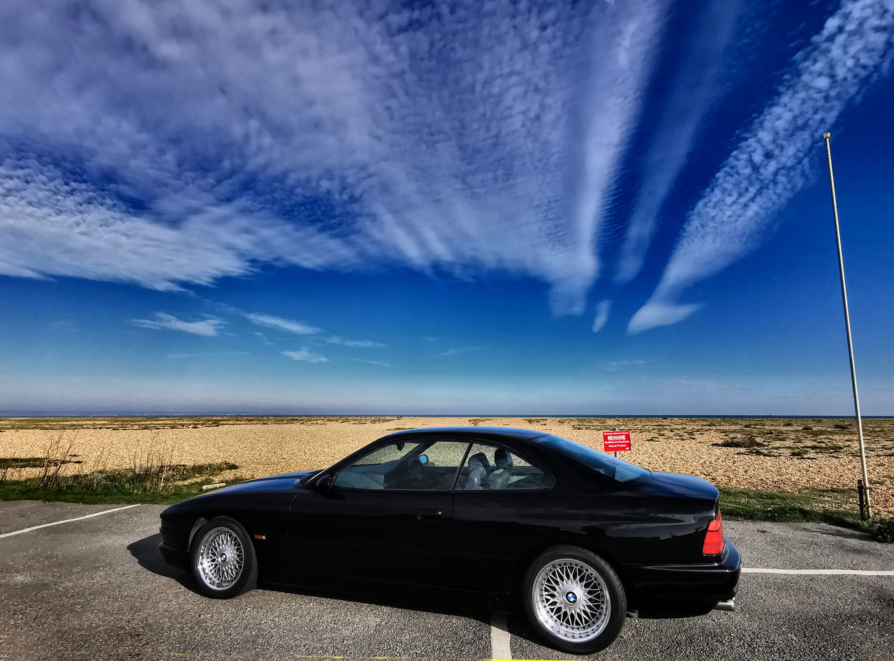 VINTAGE CAR ON ROAD AGAINST BLUE SKY