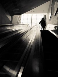 Rear view of man standing on staircase