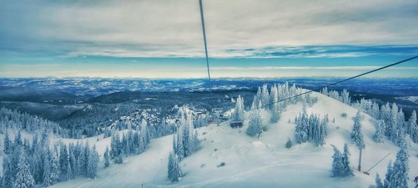 Panoramic view of snow covered land against sky