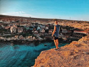 Full length of man standing on rock against sky