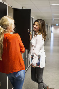 Teenage girls conversing in locker room of high school